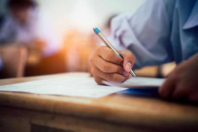 hands writing at a desk